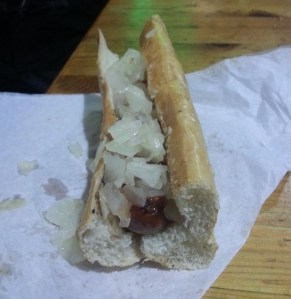 Kielbasa fresh off the grill with diced onions and ketchup